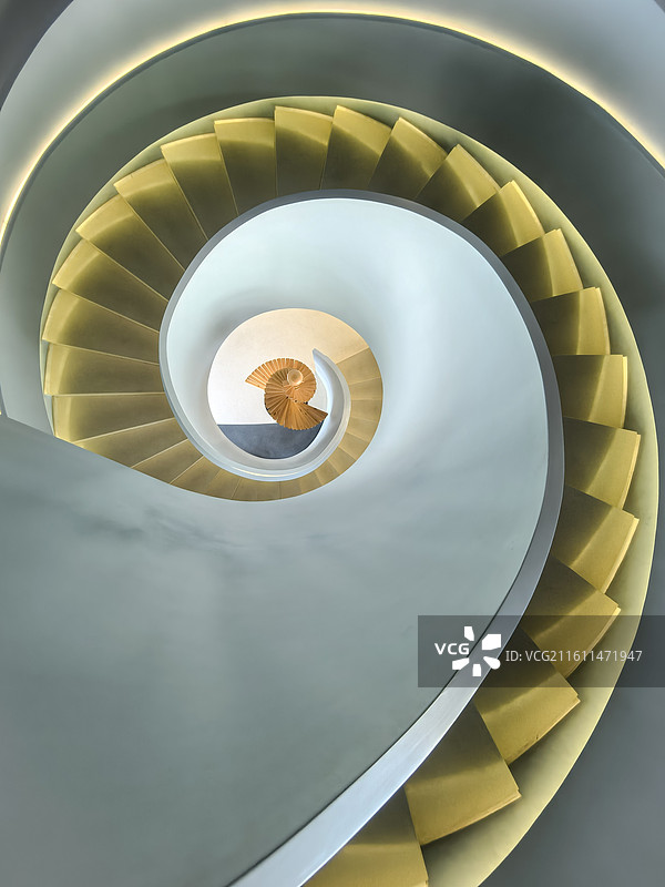《旋金》         金色阶梯旋绕成诗，冷灰墙面衬出曲线韵律，建筑的流动美学在此定格。图片素材