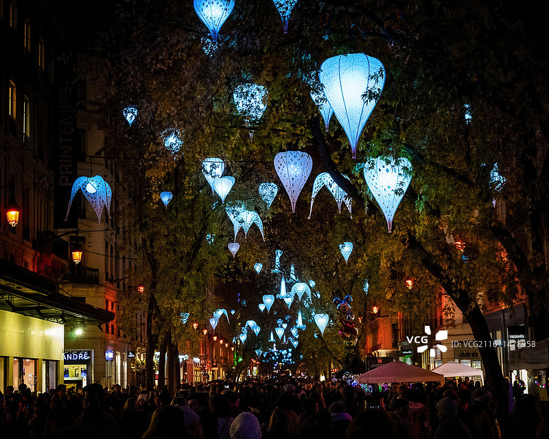 人们在晚上站在灯光下的低角度视图图片素材