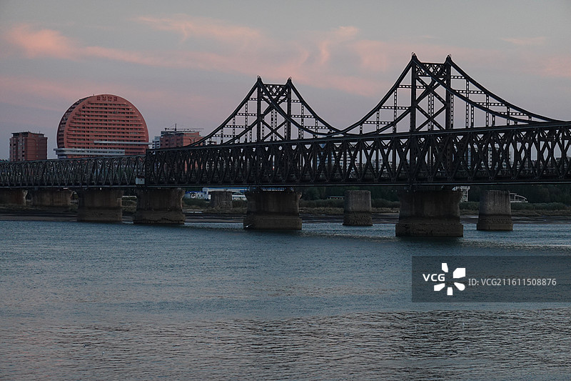 辽宁省丹东市振兴区鸭绿江断桥中朝友谊桥：远眺朝鲜新义州太阳楼晚霞夕阳图片素材