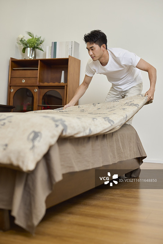 家庭主夫整理床铺图片素材