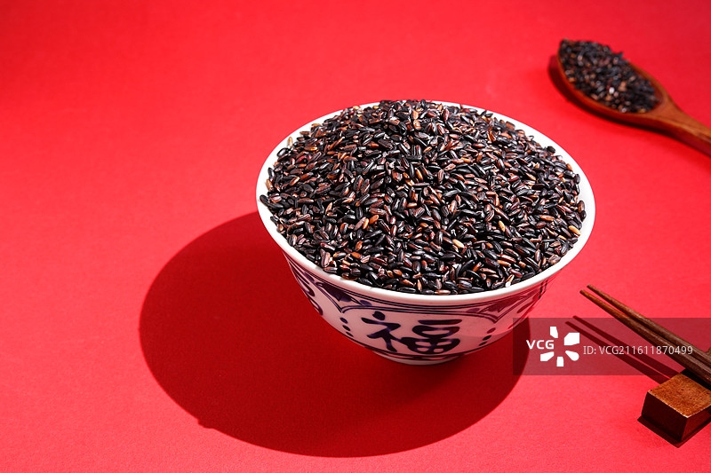 红色桌面上的一碗丰收农产品粮食大米黑米图片素材