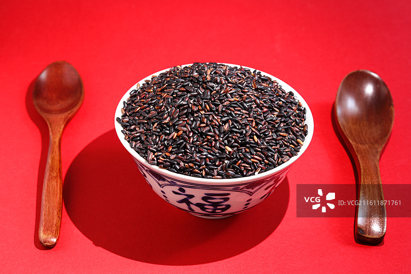 红色桌面上的一碗丰收农产品粮食大米黑米图片素材