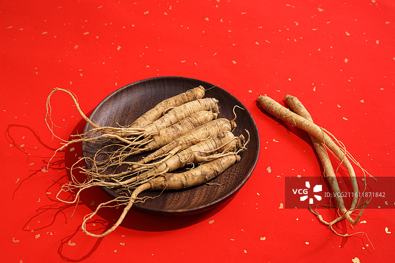 红色桌面上的传统中医中药材滋补营养品新鲜生人参图片素材