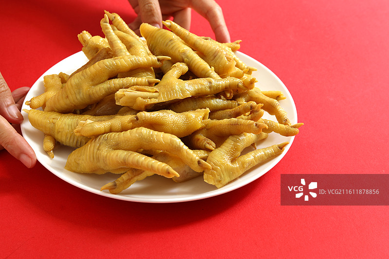 红色桌面上的一盘子中国春节传统美食广东粤菜盐焗鸡爪图片素材