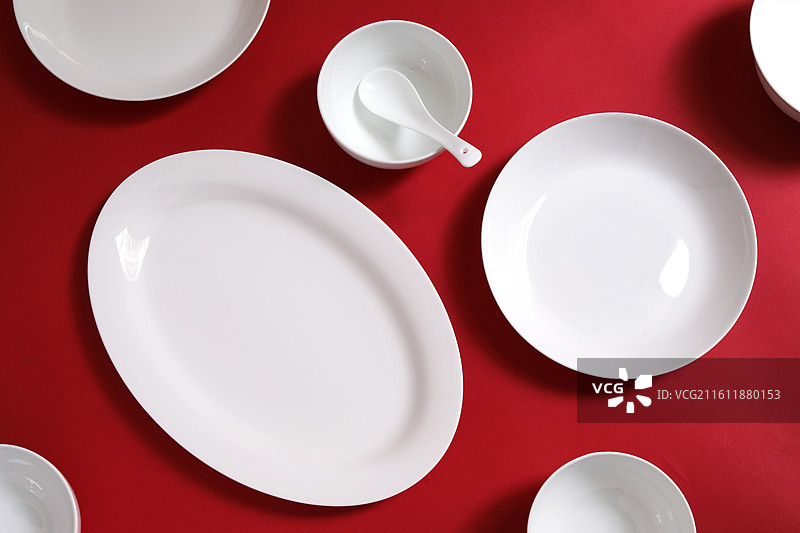 红色桌面上摆放着装美食的空盘子的背景图图片素材