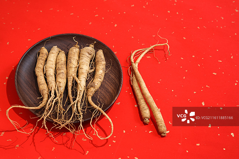 红色桌面上的传统中医中药材滋补营养品新鲜生人参图片素材