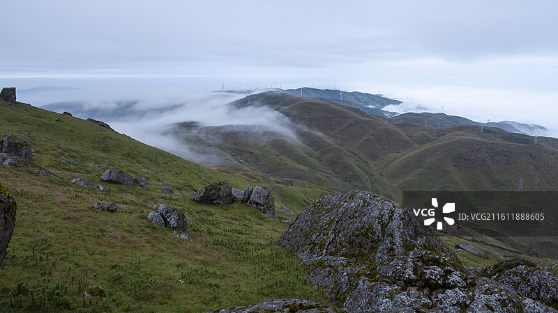云海缥缈的云南高山草甸花石头山图片素材