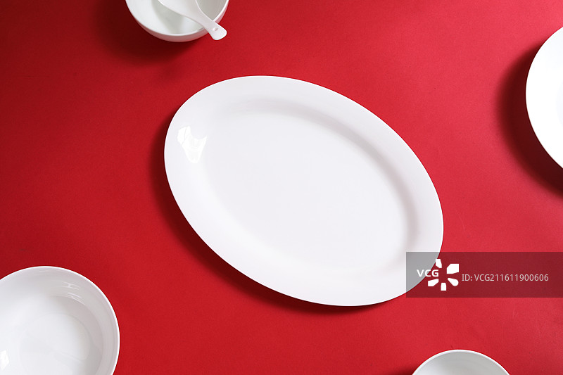 红色桌面上摆放着装美食的空盘子的背景图图片素材