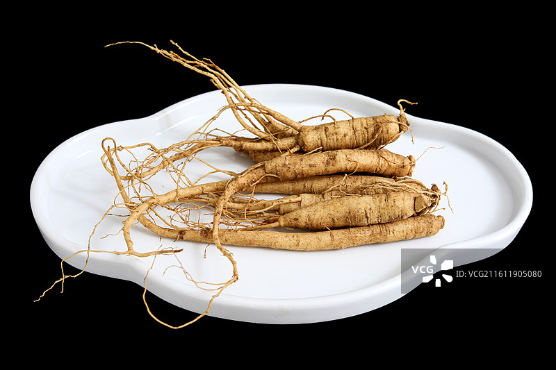 黑色背景盘子上的中国传统中医中药材滋补营养品新鲜生人参图片素材