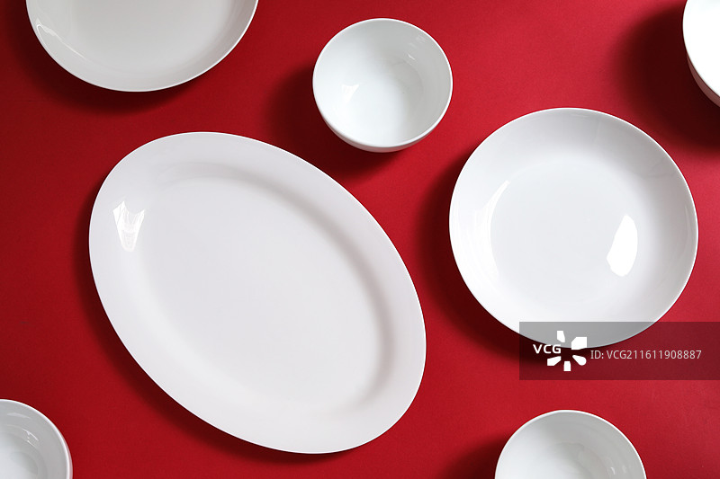 红色桌面上摆放着装美食的空盘子的背景图图片素材