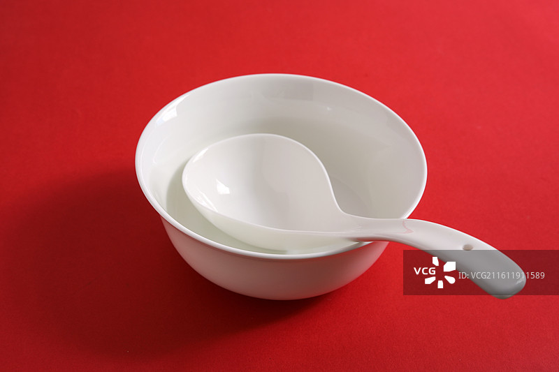 红色桌面上摆放着白色的餐具瓷器碗盘子碟子图片素材