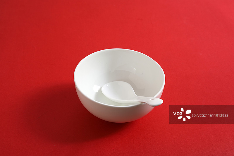 红色桌面上摆放着白色的餐具瓷器碗盘子碟子图片素材