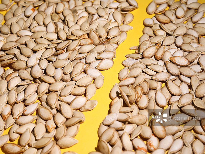 黄色桌面上摆放着的营养健康干货坚果美食南瓜子图片素材