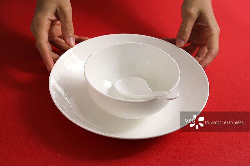 红色桌面上摆放着白色的餐具瓷器碗盘子碟子图片素材