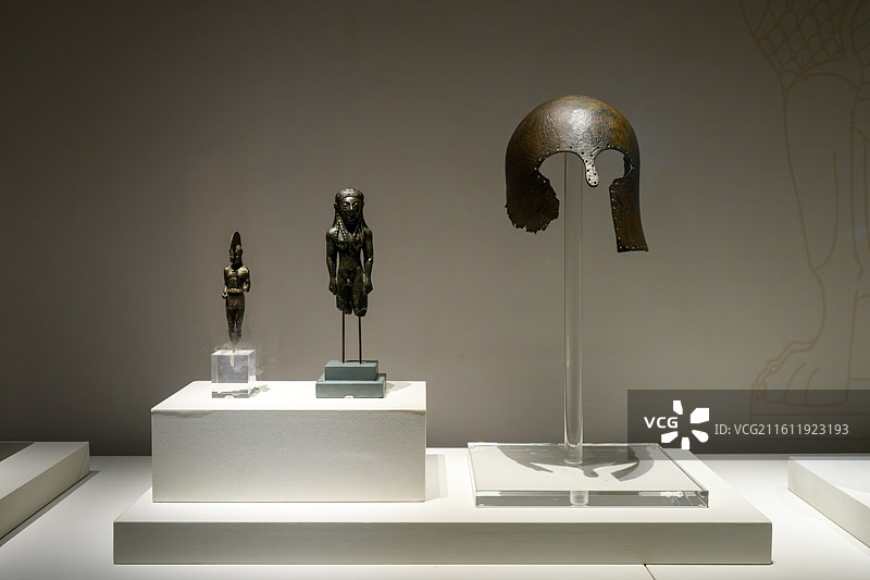 三星堆古希腊文物展上的青铜头盔和青铜雕像图片素材