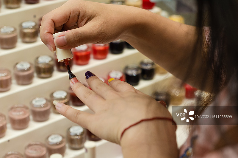 正在往手上涂抹指甲油图片素材