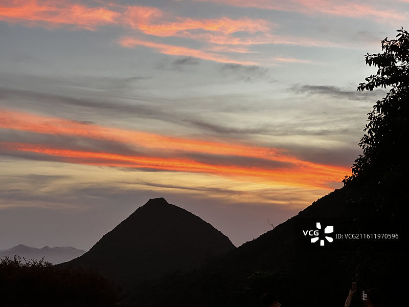 太平山顶夕阳西下彩色云朵的天空映衬下树木与山峦的轮廓图片素材