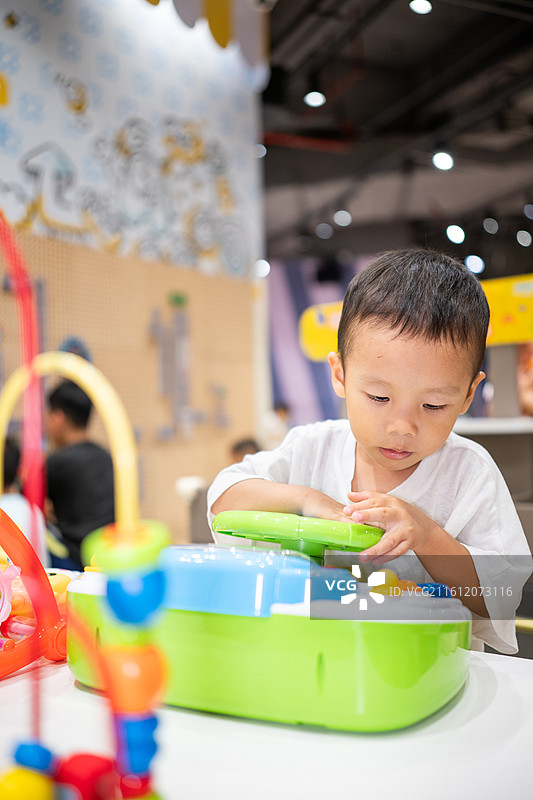 在室内儿童乐园玩耍的3岁小男孩图片素材