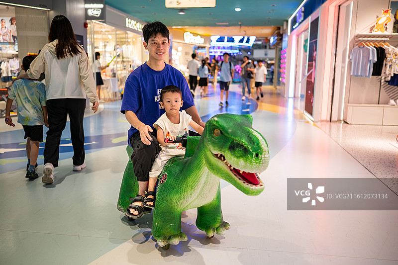 和爸爸在广州正佳广场开恐龙车的小男孩图片素材