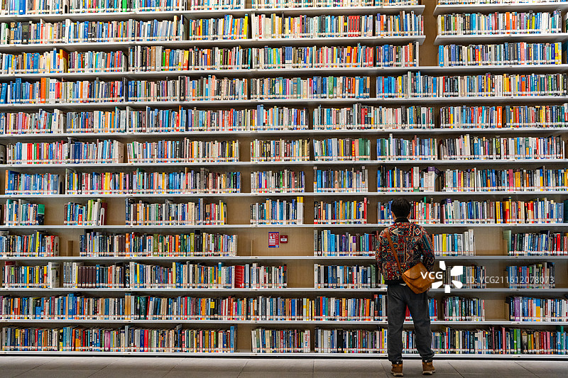 在深圳红山图书馆书墙面前看书的人图片素材
