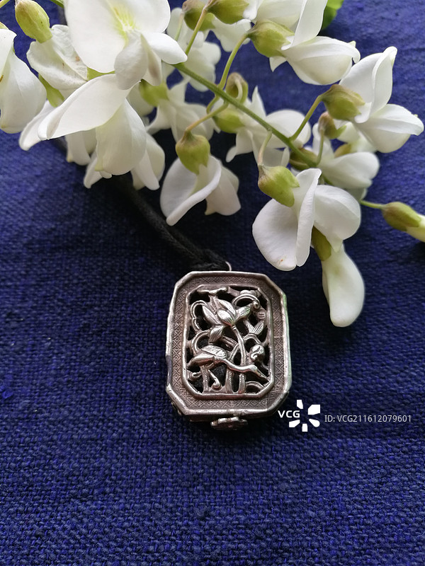 老银锁香囊首饰品。槐花古代人物纹饰猴子老粗蓝色棉粗布图片素材