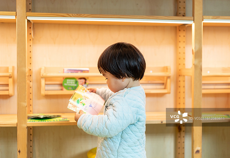 书屋内一名幼儿在阅读绘本图片素材