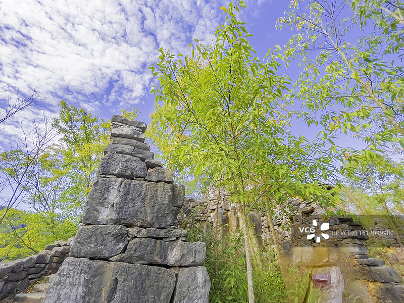 湖北省襄阳市：南漳县春秋寨，石墙，高山，关公雕像，碧水，黄叶图片素材