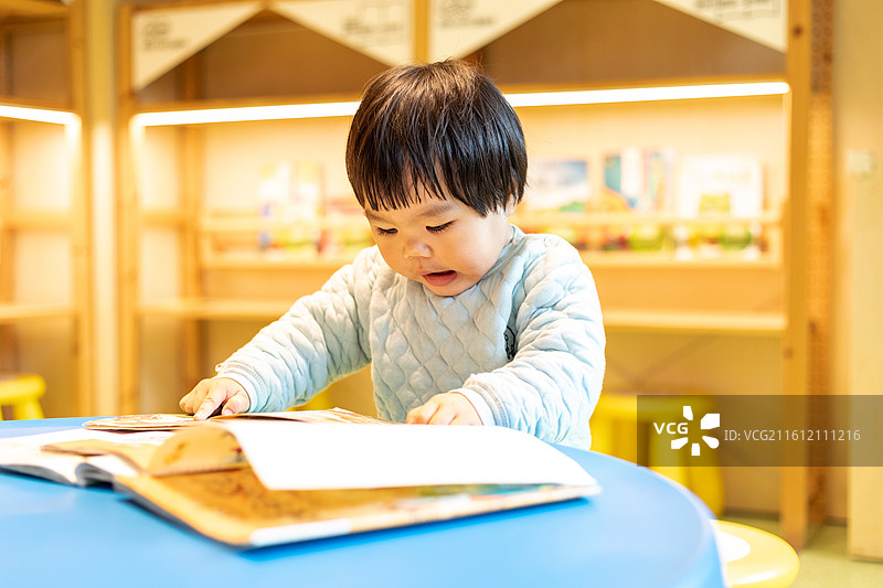 书屋内一名幼儿在阅读绘本图片素材