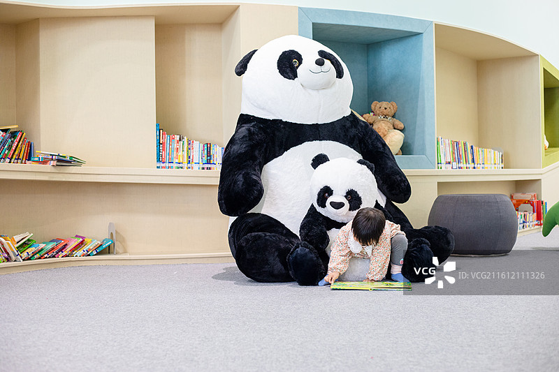 一名中国小女孩在图书馆绘本区阅读图片素材