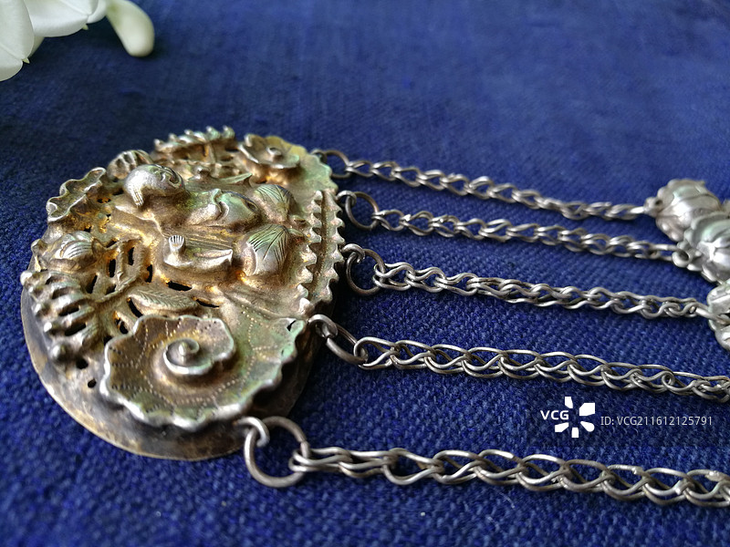 老银锁香囊首饰品。槐花古代人物纹饰猴子老粗蓝色棉粗布图片素材