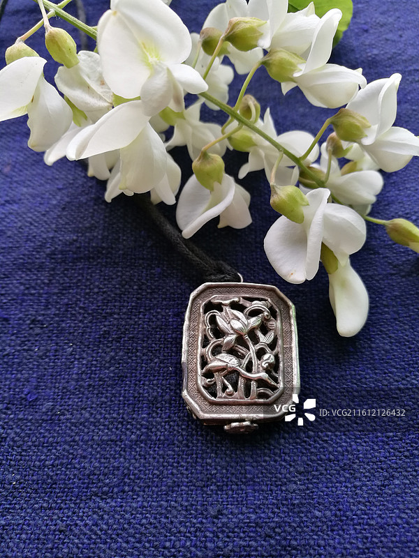 老银锁香囊首饰品。槐花古代人物纹饰猴子老粗蓝色棉粗布图片素材