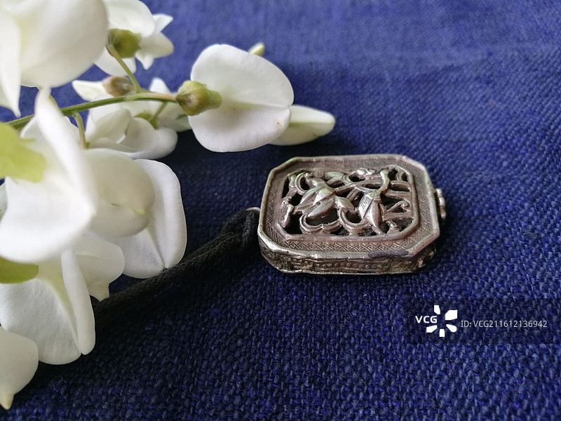 老银锁香囊首饰品。槐花古代人物纹饰猴子老粗蓝色棉粗布图片素材