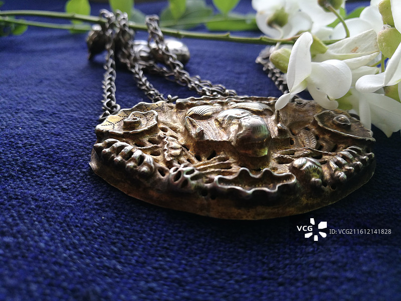 老银锁香囊首饰品。槐花古代人物纹饰猴子老粗蓝色棉粗布图片素材