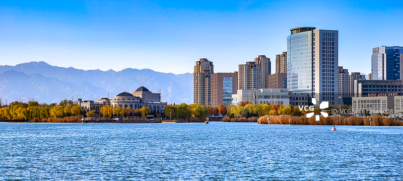 银川初冬晴日超通透视野下的阅海水上公园，蓝色湖水与贺兰山被城市未尽的秋色分隔开来图片素材