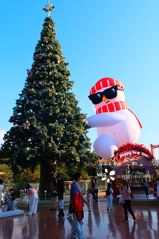 圣诞树，挂满金色和红色的球饰，背景是明亮的蓝天图片素材