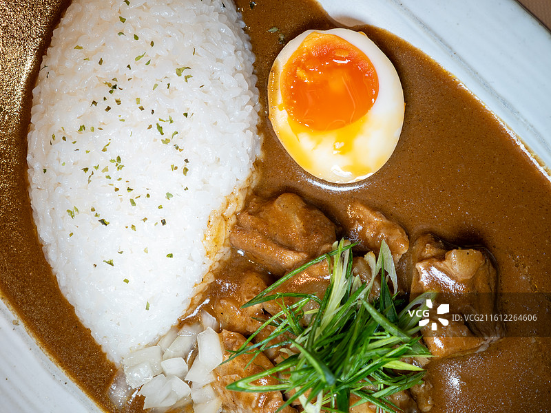 搭配溏心蛋和腌制小菜的日式猪软骨咖喱饭图片素材