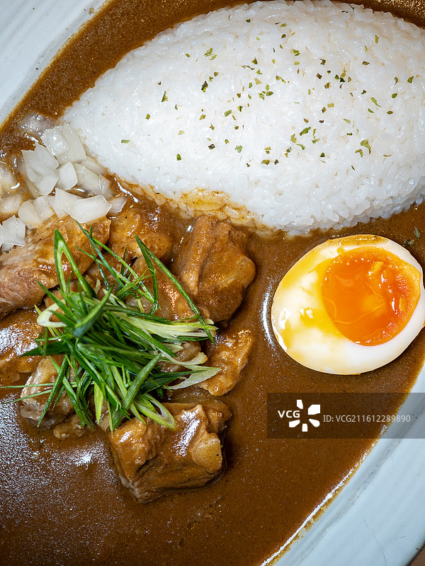 搭配溏心蛋和腌制小菜的日式猪软骨咖喱饭图片素材