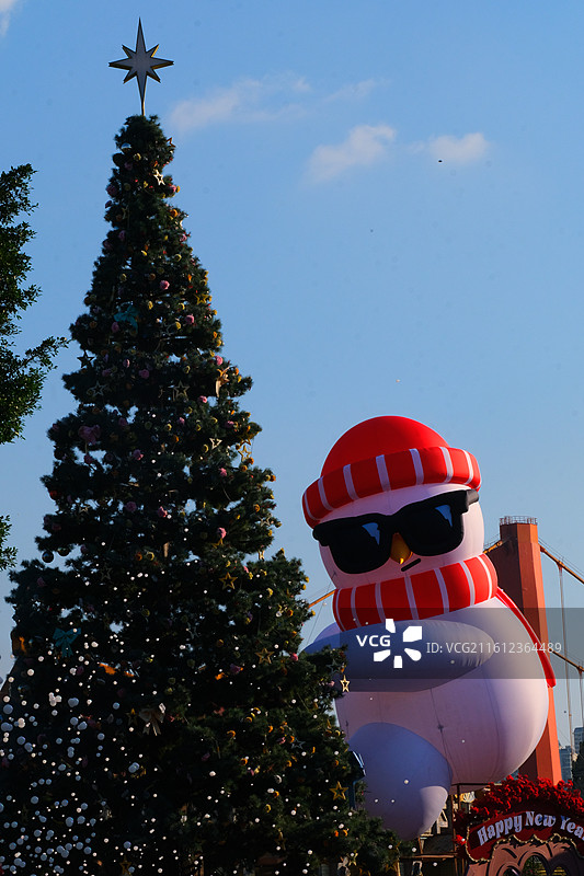 圣诞树，挂满金色和红色的球饰，背景是明亮的蓝天图片素材