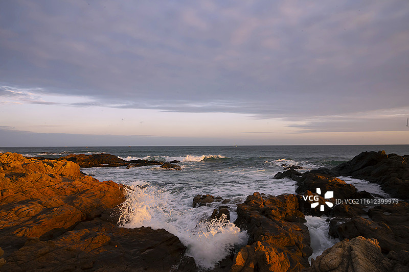 海南省陵水县清水湾夕阳下的礁石大海图片素材