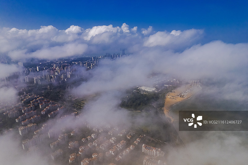 俯瞰云雾中的海口现代化海滨城市风景图片素材