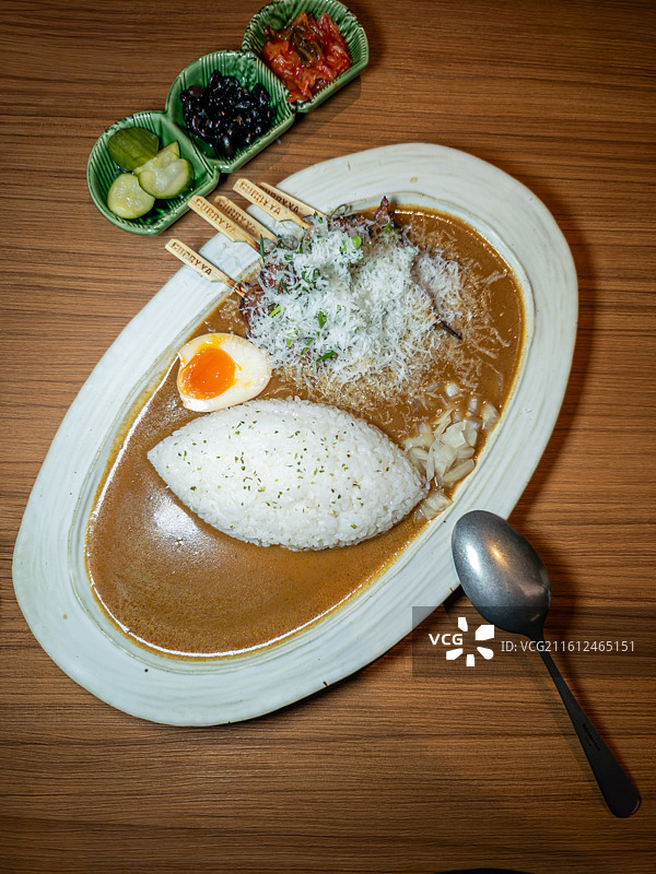 搭配溏心蛋和腌制小菜的日式猪软骨咖喱饭图片素材