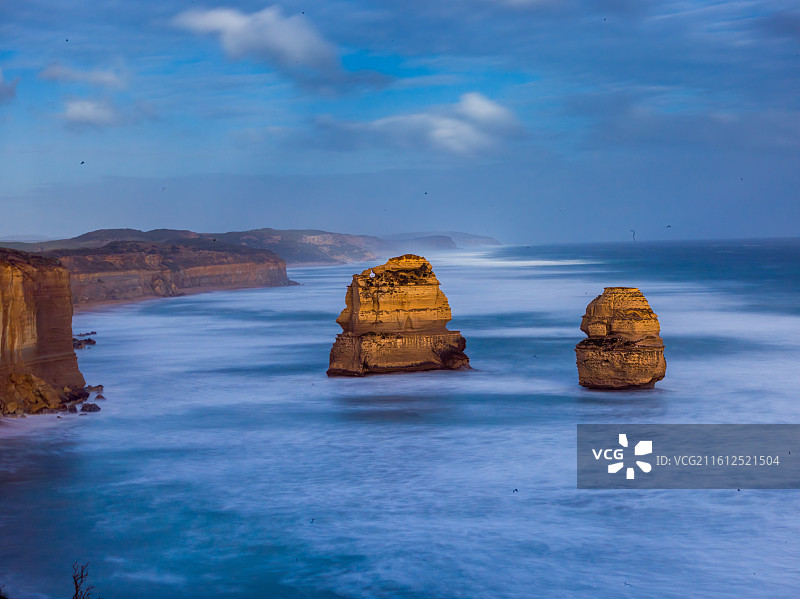 这张照片定格了澳大利亚大洋路标志性的12门徒景观。蔚蓝天空下，海浪汹涌拍打着古老的石灰岩柱。图片素材