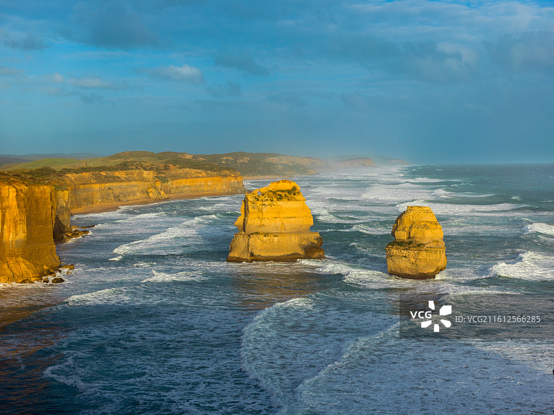 这张照片定格了澳大利亚大洋路标志性的12门徒景观。蔚蓝天空下，海浪汹涌拍打着古老的石灰岩柱。图片素材