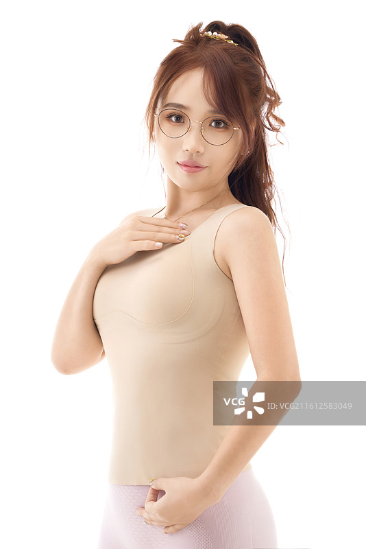 影棚拍摄白色背景前展示女性束身衣的亚洲美女图片素材