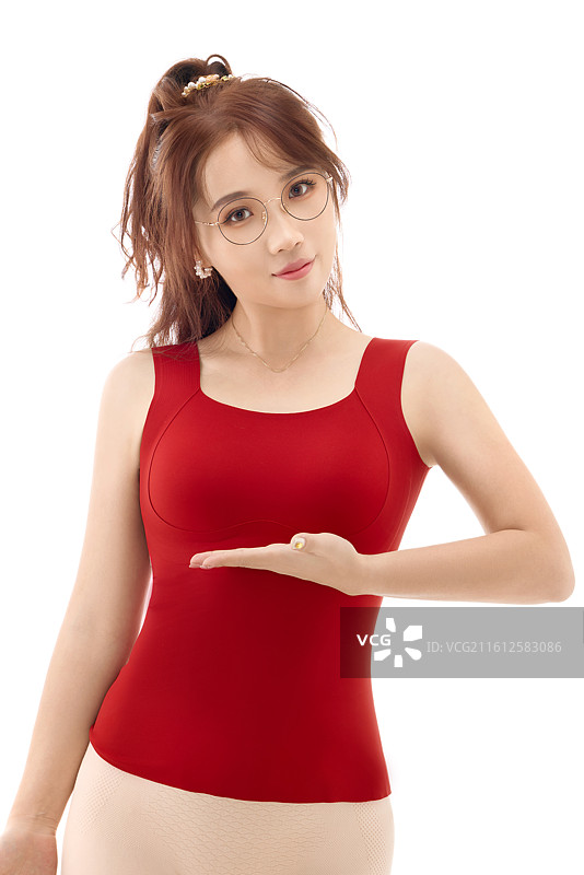 影棚拍摄白色背景前展示女性束身衣的亚洲美女图片素材