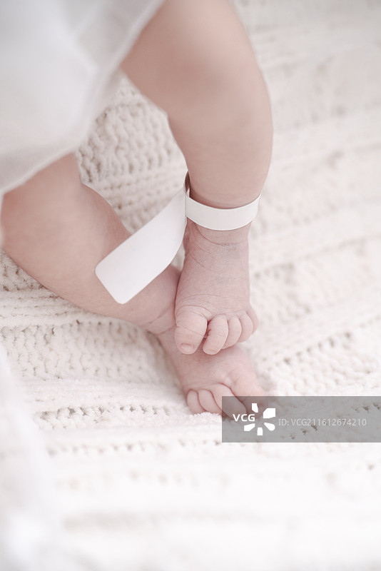轻轻抚摸新生女婴的娇嫩双腿图片素材