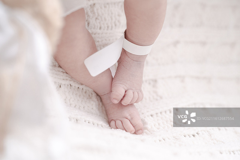 轻轻抚摸新生女婴的娇嫩双腿图片素材