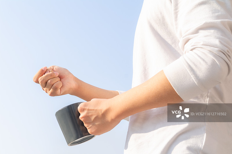 肢体障碍人士户外手持药丸与水杯进行日常服药，展示独立生活能力与医疗康复细节。图片素材