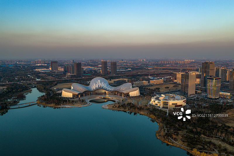 南通大剧院坐落于波光粼粼的水域之畔，独特的建筑造型在蓝天碧水的映衬下格外引人注目，剧院外观线条流畅。图片素材