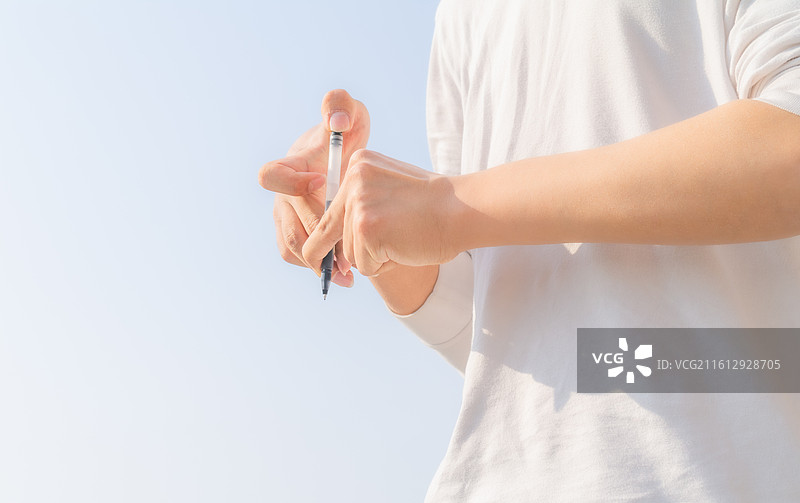 户外蓝天背景下脑瘫患者进行握笔书写与康复训练，展示受教育权与精细动作改善。图片素材